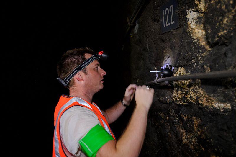 pose un détecteur solide de trace nucléaire (DSTN), pour la mesure volumique en radon dans un tunnel de la SNCF